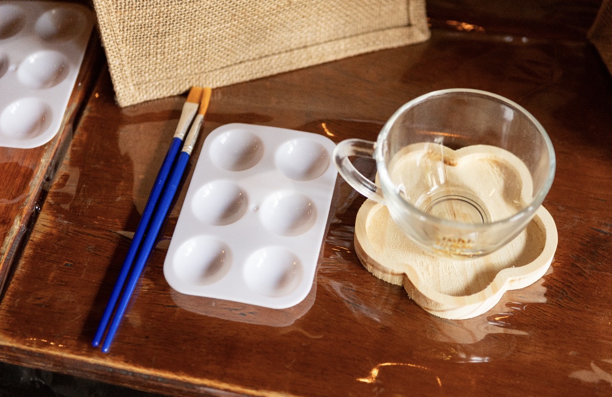 Xícara, pincéis e paleta preparados para a experiência artística